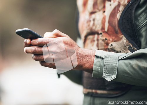 Image of Phone, camouflage and solider at war on social media or browsing internet, app or website at military or army. Hands, combat and texting on battlefield, competition or match with game safety gear