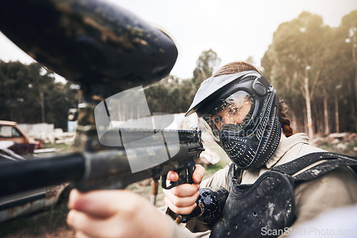 Image of Paintball, gun and aim with a sports woman training for the military or army during a war and combat game. Exercise, warrior and marker with a female athlete or soldier on a battlefield simulation