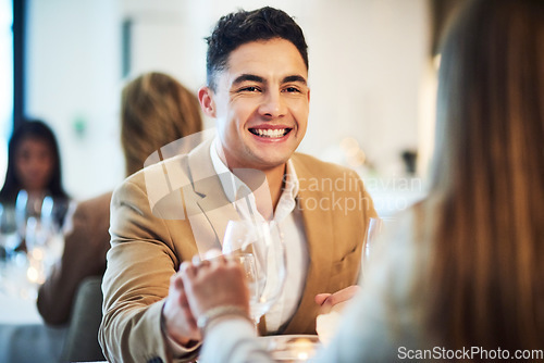 Image of Romance, love and couple on a date at restaurant holding hands for connection, unity and care. Happy, smile and man showing his girlfriend affection while at dinner for valentines day or anniversary.