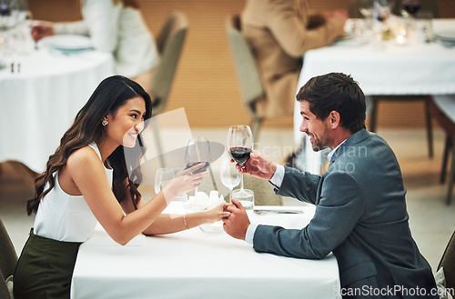 Image of Love, wine and toast with a couple in a restaurant for their anniversary celebration or romantic dinner. Night, glasses or dates with a young man and woman celebrating an event together with a cheers