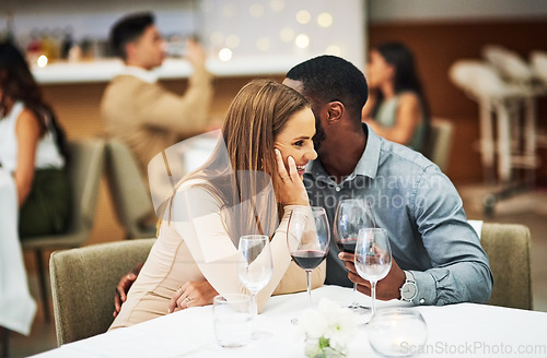 Image of Love, man whisper with woman and in restaurant with wine glasses, happiness or cheerful on Valentines day. Romance, couple or flirty for quality time, romantic or conversation with fine dining or joy