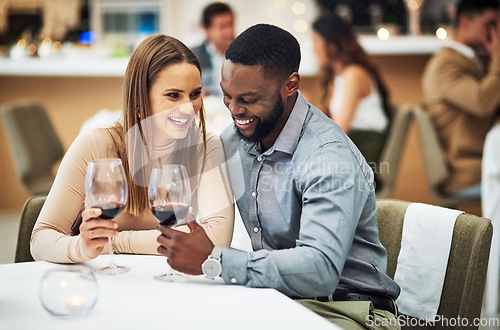 Image of Cheers, love and couple on a date in a restaurant for valentines day, romantic event or anniversary. Happy, smile and interracial man and woman drinking wine, talking and bonding at a luxury dinner.