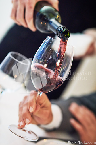 Image of Hands, glass and waiter pouring wine for serving, catering or working at restaurant for customer service. Hand of diner worker providing alcohol in champagne glasses for hospitality or fine dining