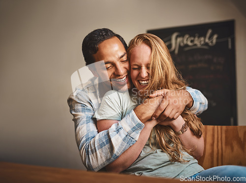 Image of Happy couple, hug and smile for romance, embrace or relationship happiness at indoor restaurant. Young man hugging woman and smiling for fun love or dinner date spending bonding time at cafe together