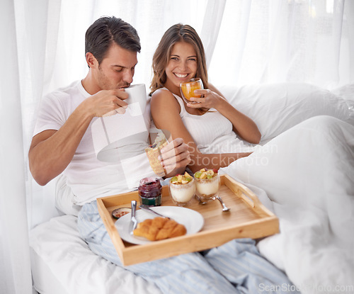 Image of Breakfast, bed and couple portrait with love, care and morning food together at home. Happiness, smile and relax young people eating and drinking in a house for anniversary or valentines day
