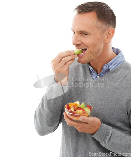 Image of Mature man eating fruits isolated on a white background for healthy green lunch, diet choice or nutritionist breakfast. Professional vegan person or model with fruits salad, food or apple in studio