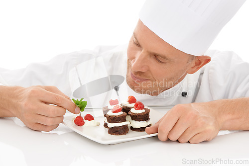 Image of Baking, presentation and chef with a dessert for catering isolated on a white background. Cooking, professional and man plating a chocolate cake and fruit on a plate for service on a backdrop