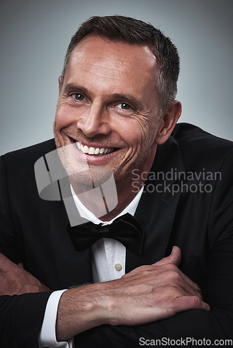 Image of Happy, portrait and man in a tuxedo in studio for a luxury valentines day, anniversary or romantic date. Happiness, smile and mature male model or gentleman in elegant formal suit by gray background.