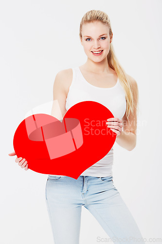 Image of Valentines day, portrait and woman with a heart in a studio with a smile for a romantic gesture. Happiness, excited and female model from Australia holding a love shape isolated by a white background