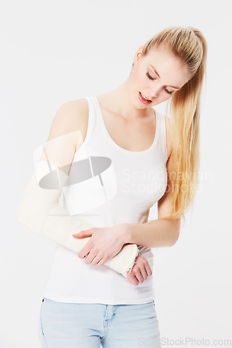 Image of Injury, pain and woman with a broken arm after an accident isolated on a white background. Hurt, handicap and girl holding an injured and bandaged limb for an emergency in a brace on a backdrop