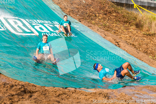 Image of Athletes sliding to mud and water