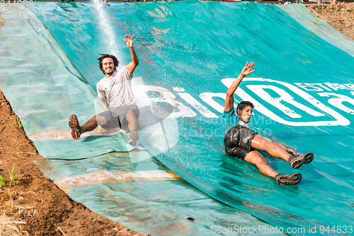 Image of Athletes sliding to mud and water