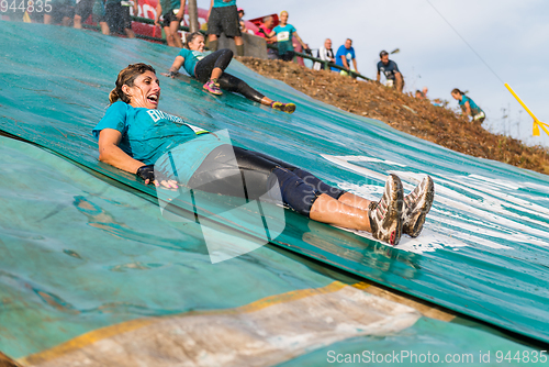 Image of Athletes sliding to mud and water