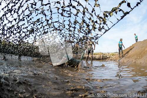 Image of Athletes crawling through mud