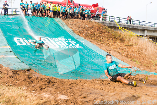 Image of Athletes sliding to mud and water