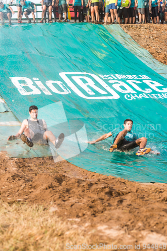 Image of Athletes sliding to mud and water