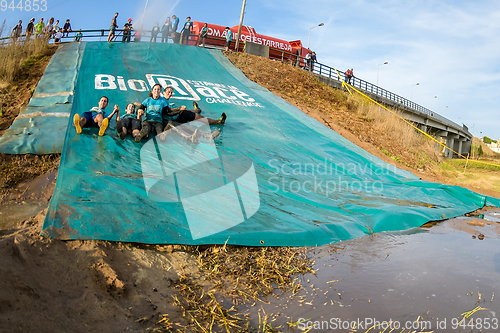 Image of Athletes sliding to mud and water