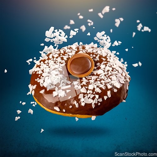 Image of Chocolate donut with coconut flackes flying i