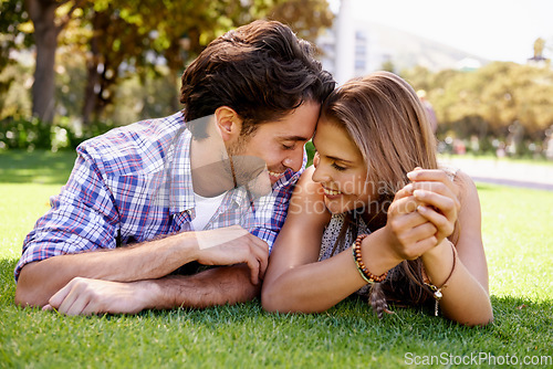 Image of Couple, love or forehead touch on grass date, nature park or garden bonding on valentines day, romance or anniversary trust. Smile, happy woman or man lying in relax environment or partnership picnic