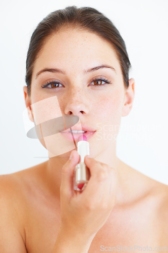 Image of Woman, face and lipstick for makeup, cosmetics or skincare isolated against a white studio background. Portrait of beautiful happy female applying cosmetic product on lips for beauty or self love