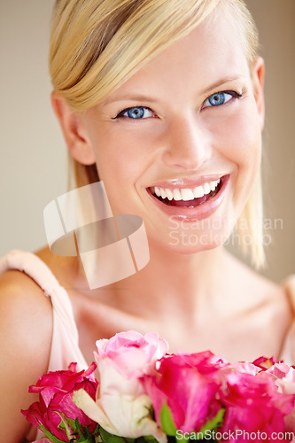 Image of Flowers, portrait and happy woman in a studio with roses for valentines day, anniversary or romantic event. Happiness, smile and female from canada with a pink floral bouquet by a nude background.