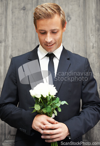 Image of Love, man and bunch of white roses, smile and gift for date, relationship and guy with joy. Romance, male and gentleman with suit, plants or flowers for wedding, happiness or celebration with bouquet