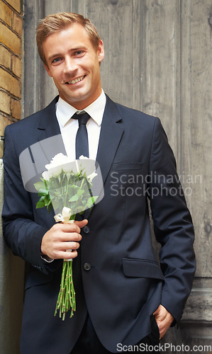 Image of Rose, portrait and man with gift for valentines day, anniversary or first date while waiting on door background. Face, flowers and gentleman with sweet, gesture or offering for love and romance