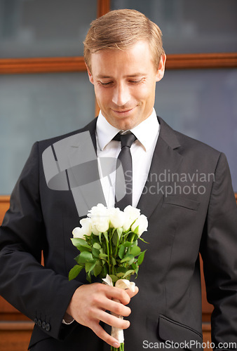 Image of Love, romantic and man with flowers for valentines day, romance or gesture while standing against a wall background. Roses, happy and gentleman with bouquet for sweet, anniversary gift or first date