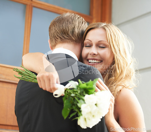 Image of Couple, flowers and hug with smile for valentines day embrace or relationship celebration for date. Happy woman hugging man and holding white roses or bouquet to celebrate the special month of love