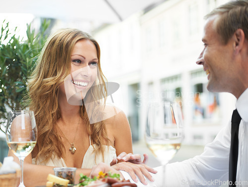 Image of Food, wine and couple at a restaurant for love, celebration or anniversary dinner, happy and bonding. Champagne, romance and woman flirting with man at birthday, event or social gathering together