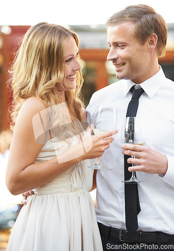 Image of Love, wine and couple at a party, smile and happy while talking, flirting and bonding at outdoor event. Champagne, romance and man with woman in romantic moment, cheerful on first date or anniversary