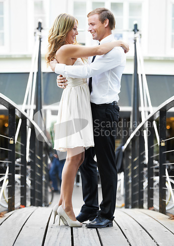 Image of Couple, bridge and hug outdoor with love, care and romantic valentines date with happiness together. Man, woman and intimate embrace for happy bonding, city adventure and funny moment for comic laugh