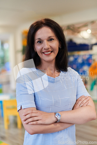 Image of Portrait of a teacher in a preschool institution, in the background of the classrooms