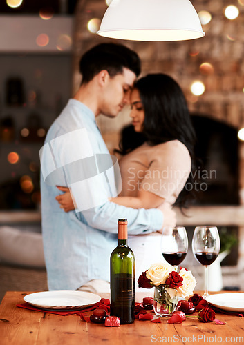 Image of Love, wine and romance, couple hug on valentines day date at home with rose petals and bokeh. Date night, man and woman embrace in living room, valentine celebration and happy relationship together.