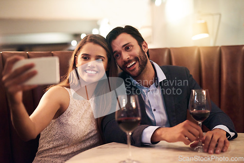 Image of Selfie, wine and valentines day with a couple in a restaurant for a romantic fine dining celebration of love. Photograph, alcohol or anniversary with a man and woman celebrating a milestone together