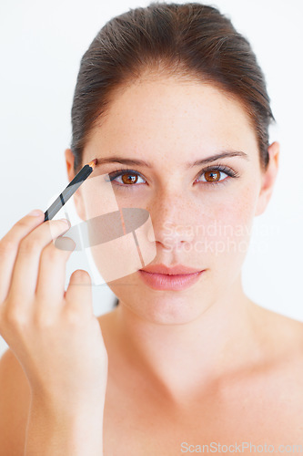 Image of Makeup, beauty and portrait of woman with eyebrow pencil in studio for shape or grooming on white background. Face, brow and girl model with microblading tool for drawing, filling or product isolated