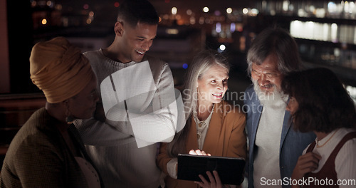Image of Tablet, collaboration and night with a business team working together in the city on their office balcony. Finance, teamwork and meeting with a man and woman employee group talking strategy outside