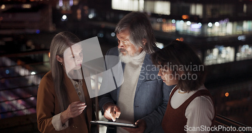 Image of Tablet, collaboration and night with a business team working together in the city on their office balcony. Finance, teamwork and meeting with a man and woman employee group talking strategy outside