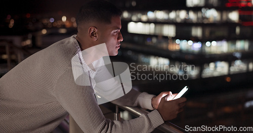 Image of Business man, phone and night data while online on an urban building rooftop typing email, search or communication for networking on trading app. Entrepreneur on terrace in dark with 5g network