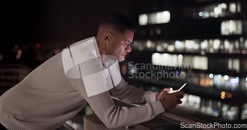 Image of Business man, phone and night data while online on an urban building rooftop typing email, search or communication for networking on trading app. Entrepreneur on terrace in dark with 5g network