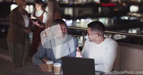 Image of Laptop, collaboration and night with a business team working together on balcony in the city. Teamwork, computer and overtime with a man and woman employee at work late on a project deadline