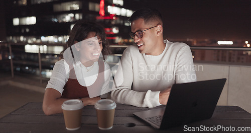 Image of Laptop, collaboration and night with a business team working together on balcony in the city. Teamwork, computer and overtime with a man and woman employee at work late on a project deadline