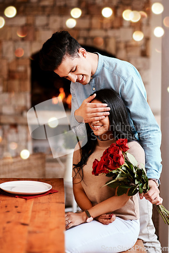 Image of Surprise, love and man with flowers for his wife while on a romantic date for valentines day. Happy, smile and husband with a bouquet of red roses for his woman while at dinner for their anniversary.