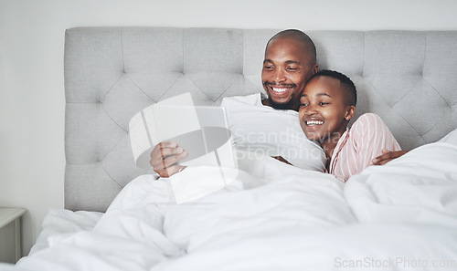 Image of Tablet, bedroom and a black couple streaming an online subscription service while in their bed together to relax. Social media, entertainment or video with a man and woman relaxing in the morning