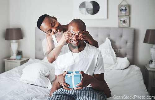 Image of Surprise, gift and couple in bedroom with box for anniversary, valentines day or birthday celebration. Love, dating and black woman cover eyes of man for present for romance, affection and bonding