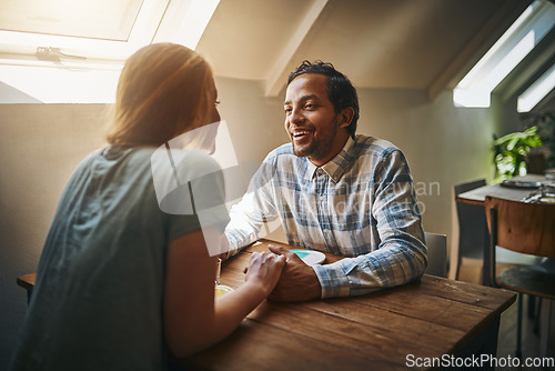 Image of Valentines, couple love and holding hands at restaurant on table, talking and laughing at joke. Comic, romance diversity and affection of man and woman on date, having fun and enjoying time at cafe