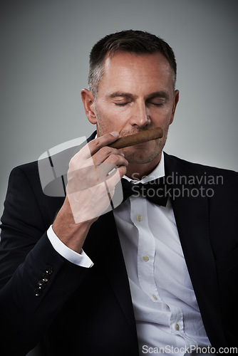 Image of Luxury, wealth and face of man with cigars for smoking habit on gray background for class, power and success. Mafia mockup, business gangster and isolated senior male smell tobacco for rich lifestyle