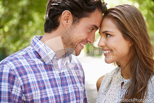 Image of Face, love and couple in park with forehead, touch and bonding against a blurred background. Happy, embrace and man with woman in nature, smile and excited on Valentines Day for relationship and date