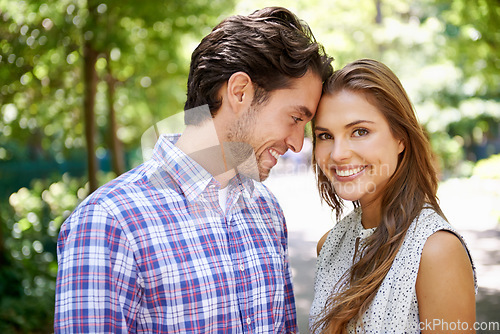 Image of Portrait, couple and hug in park with forehead, touch and bonding against a blurred background. Face, embrace and man with woman in nature, smile and excited for reunion, relationship or togetherness