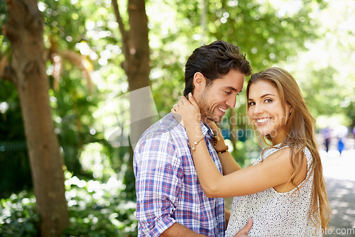 Image of Couple, portrait and hug in park happy, touch and bonding against with love. Date, embrace and man with woman in nature, smile and excited for reunion, relationship and Valentines Day